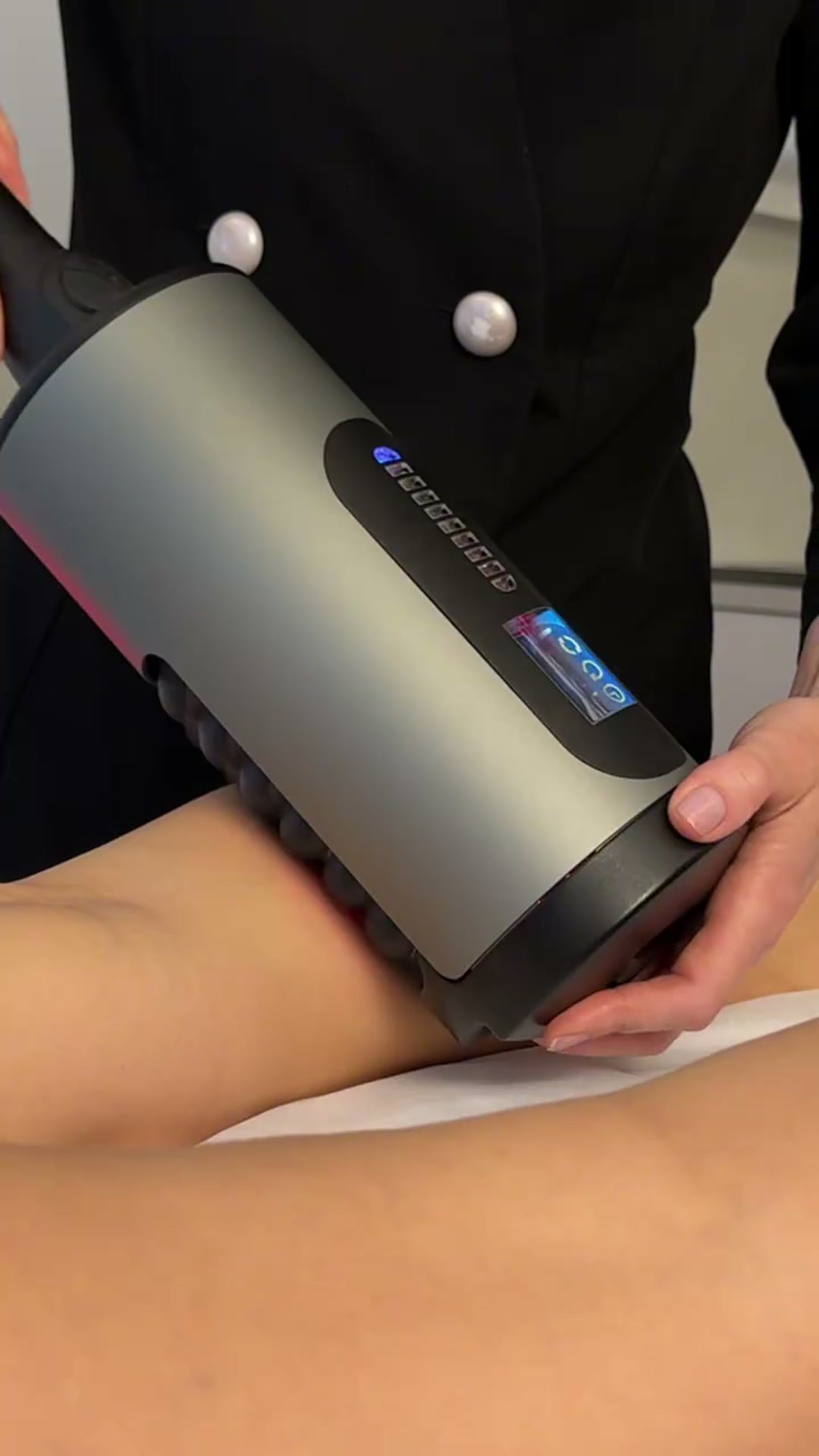 Handstycket med kompressionssfärer arbetar över låret under en Belle CelluDerm-behandling